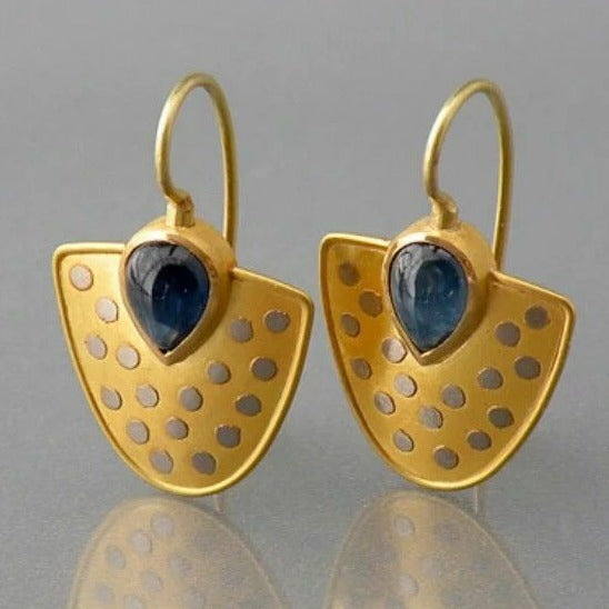 Elegante placa dorada con brillantes pendientes de cristal azul