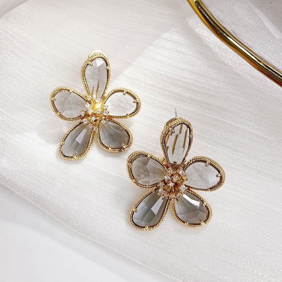 Elegantes par de pendientes retorcidos con brillantes circones y diseño de flores de riqueza