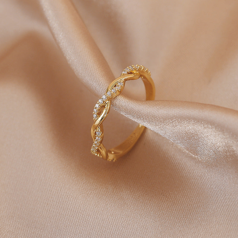 Anillo elegante ajustable con piedras de zirconia trenzadas artísticamente en un oro noble