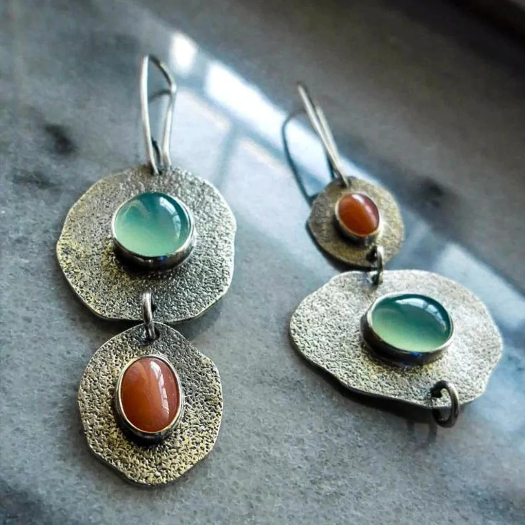 Pendientes vintage elegantes con brillantes piedras azul y naranja en un hermoso chapado de plata.