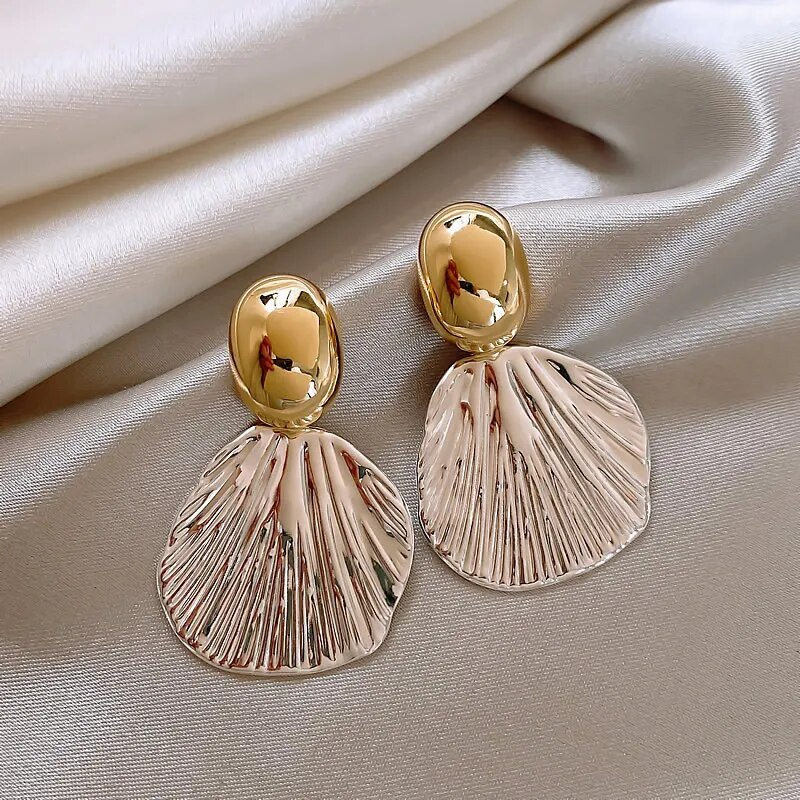 Pendientes de concha dorados con diseño elegante