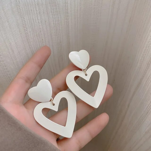 Pendientes de corazón hueco elegantes en blanco radiante