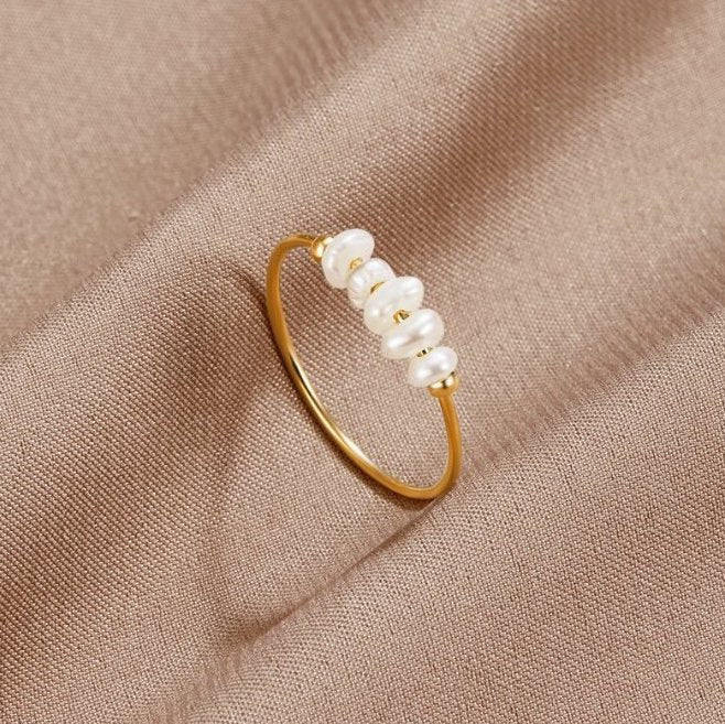 Anillo elegante dorado con perlas estilizadas