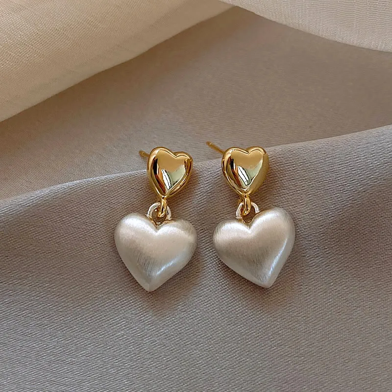 Hermosos pendientes en forma de corazón dorados con perlas elegantes