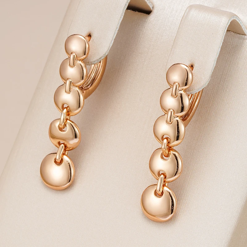 Elegantes par de pendientes de declaración dorados con un diseño colgante chic