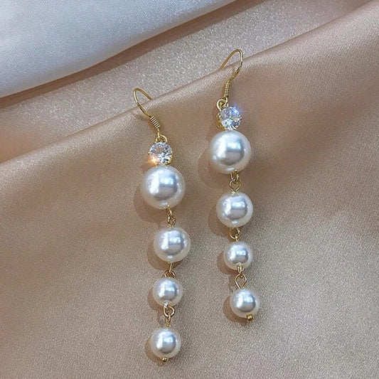 Pendientes elegantes dorados con colgantes de perlas destelleantes