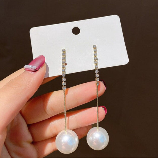 Elegantes arete de oro con brillantes circonitas y colgantes de perlas