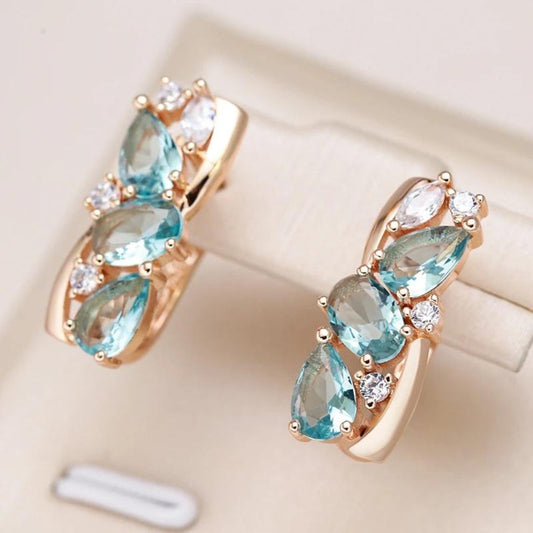 Pendientes elegantes dorados con brillantes piedras de circonita azul
