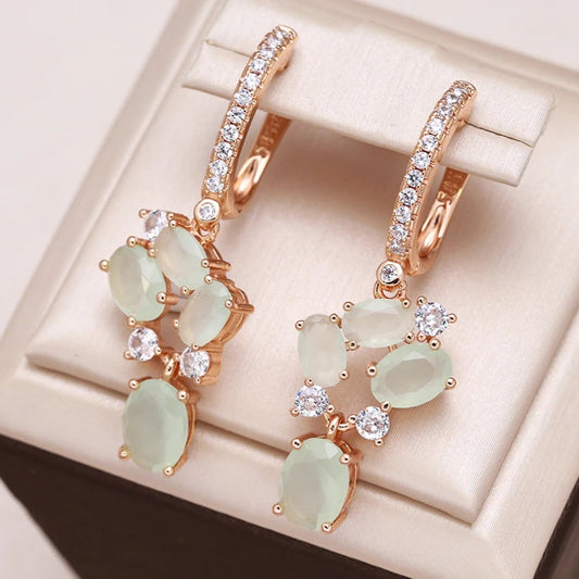Fascinantes aretes dorados con brillantes cristales verdes y deslumbrante circonita