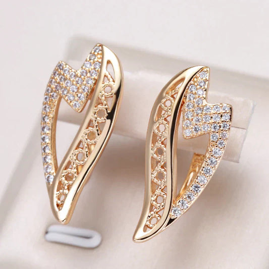 Pendientes dorados brillantes con chispeantes piedras de circonio