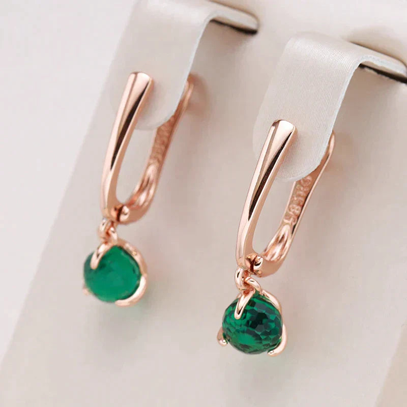 Elegantes aretes dorados con brillantes cristales verdes