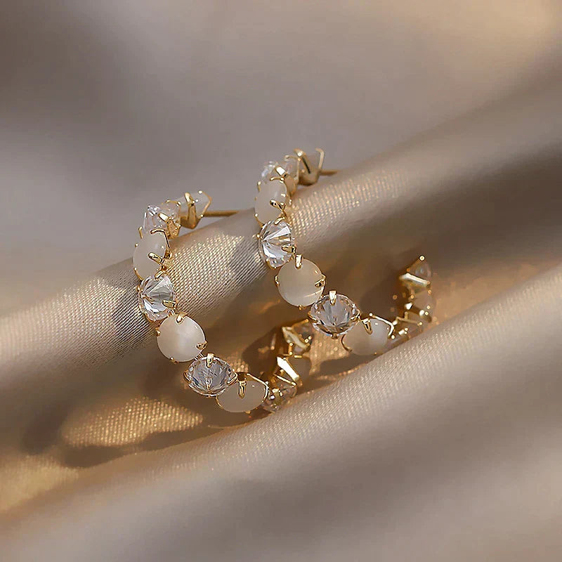Pendientes de oro elegantes con opal blanco brillante y circonitas