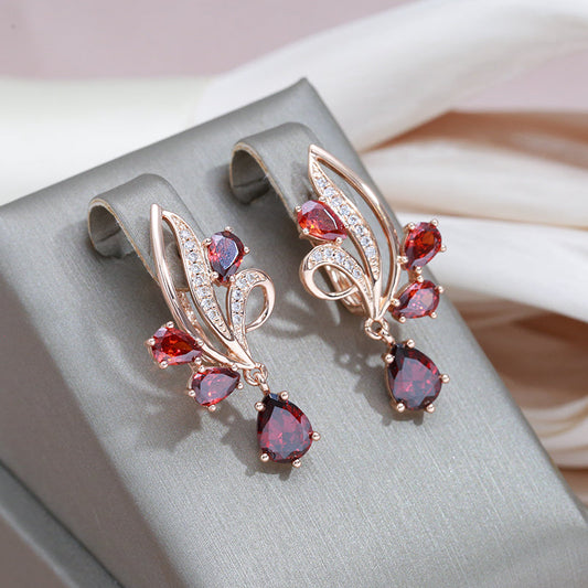 Pendientes de oro lujosos con brillantes cristales rojos