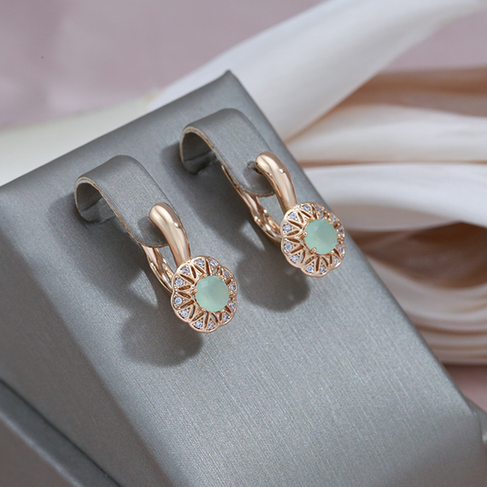 Pendientes dorados elegantes con zirconias brillantes y un impresionante ojo verde