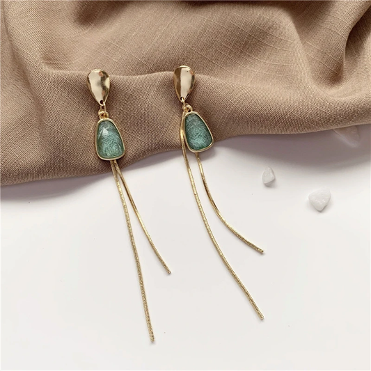Elegantes aretes de oro con brillante piedra turquesa