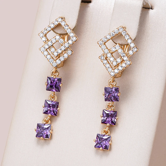 Elegantes pendientes dorados con brillantes cristales morados