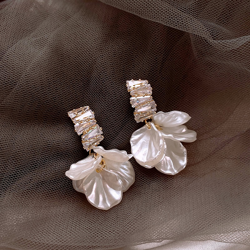 Elegantes pendientes de oro con pétalos de flores blancos