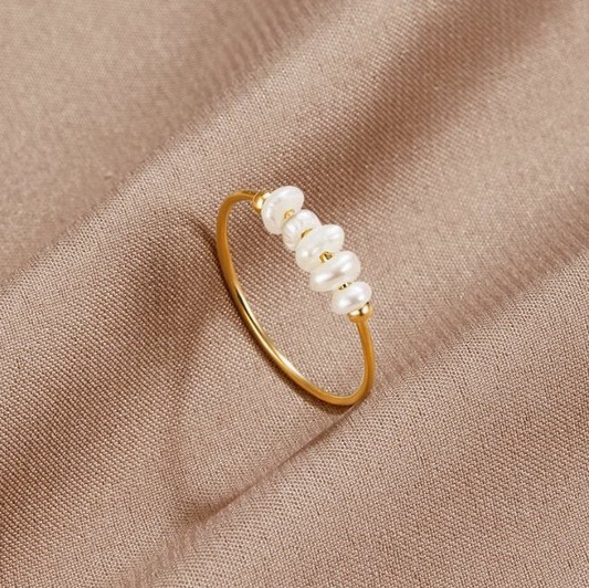 Anillo elegante dorado con perlas estilizadas