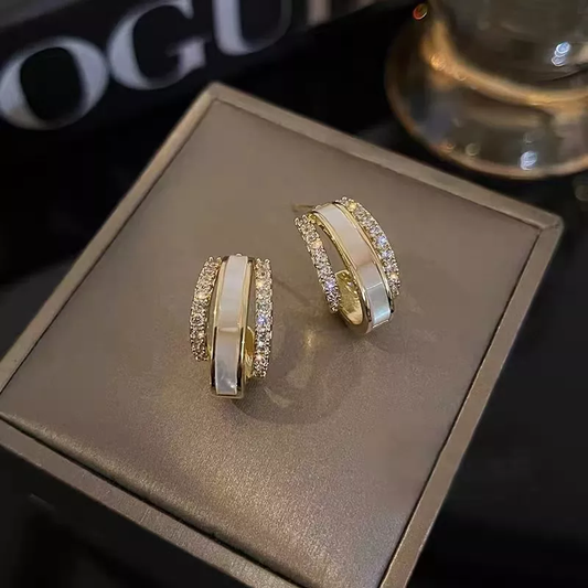 Pendientes blancos elegantes con brillantes piedras de circonita