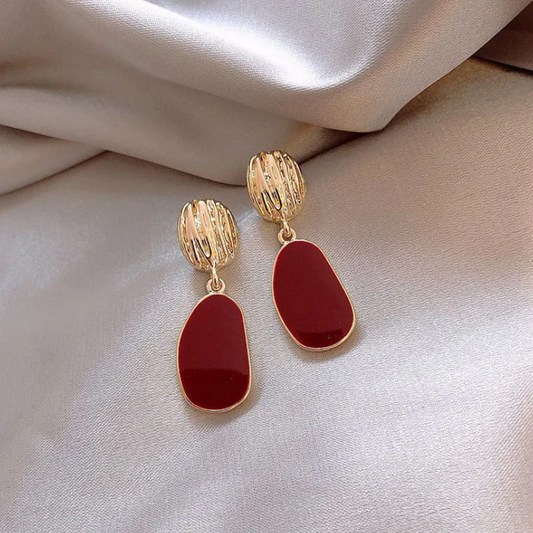 Pendientes dorados elegantes con un toque de rojo