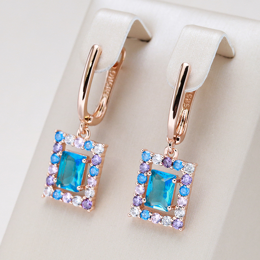Pendientes dorados lujosos con brillantes cristales cúbicos azules